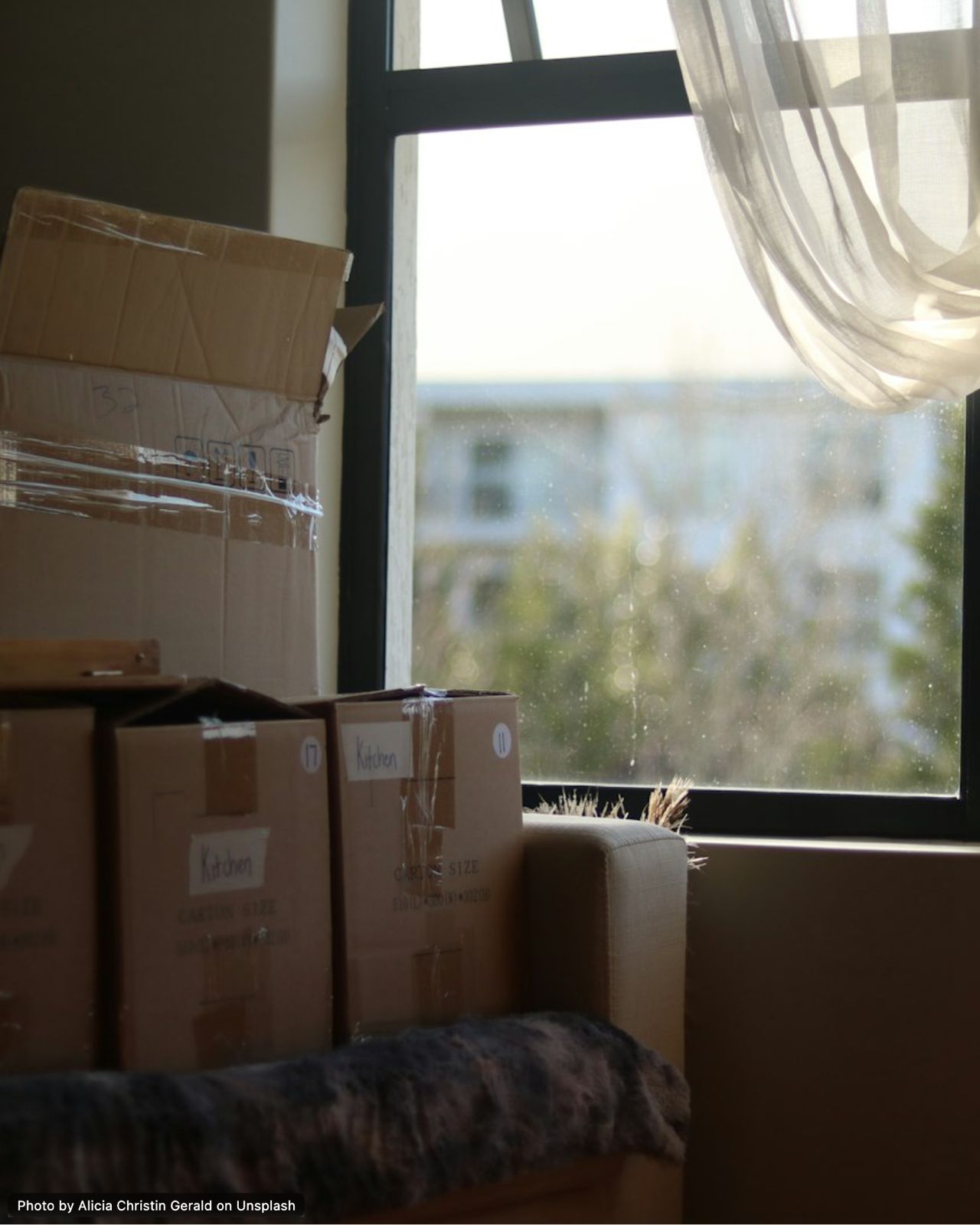 Beschriftete Umzugskartons bei einer Haushaltsauflösung am Fenster
