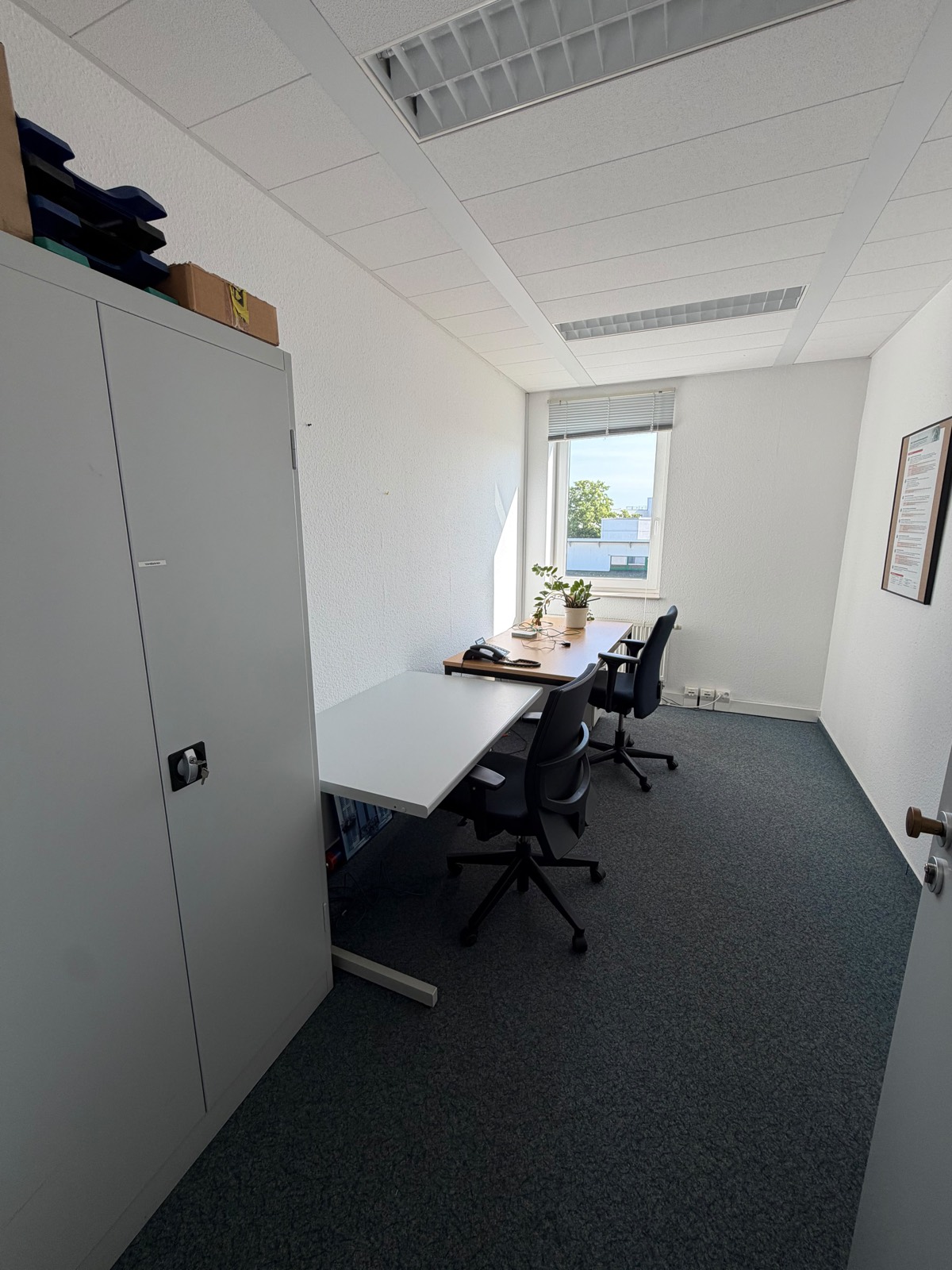 Belegtes Büro mit Schrank und Schreibtischen vor der Büroauflösung