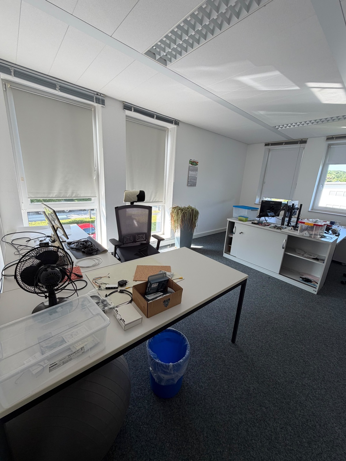 Großes Büro voll mit Möbeln, Technik und Kartons vor der Büroauflösung