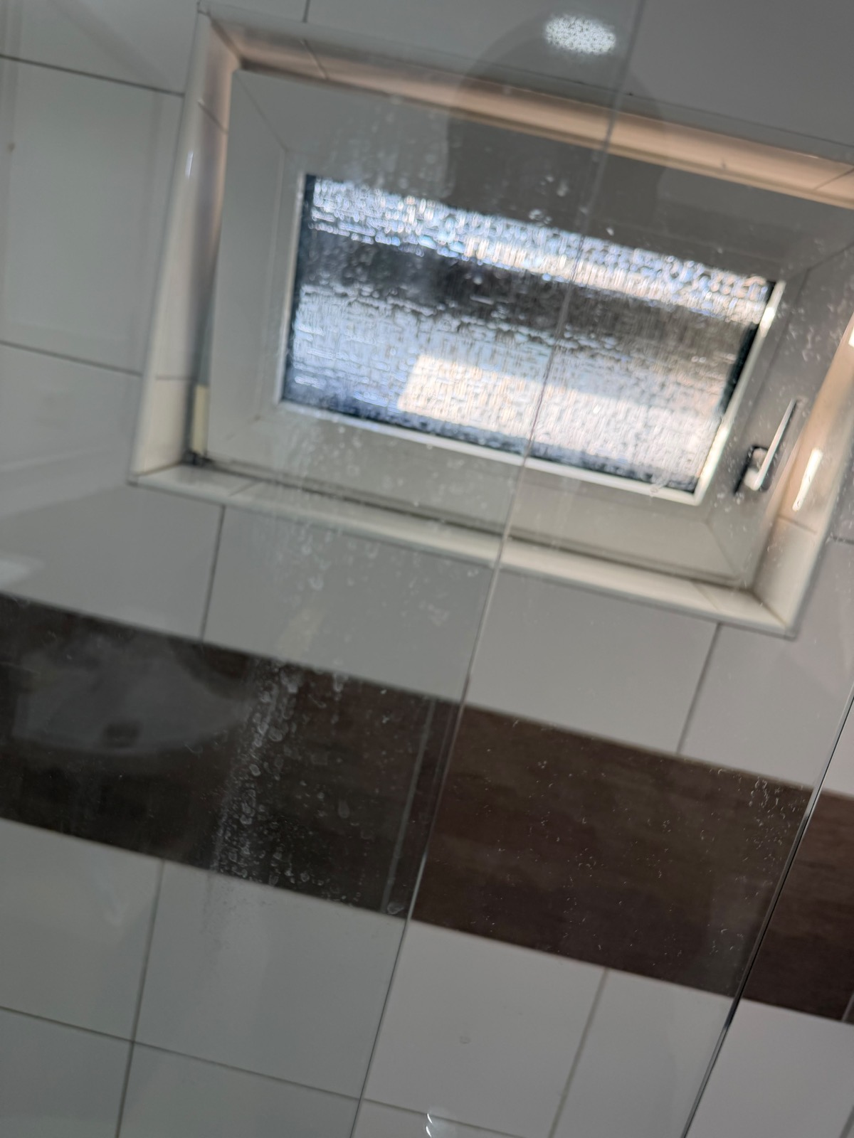 Verkalkte, verschmutzte Dusche mit Fensternische vor der Reinigung