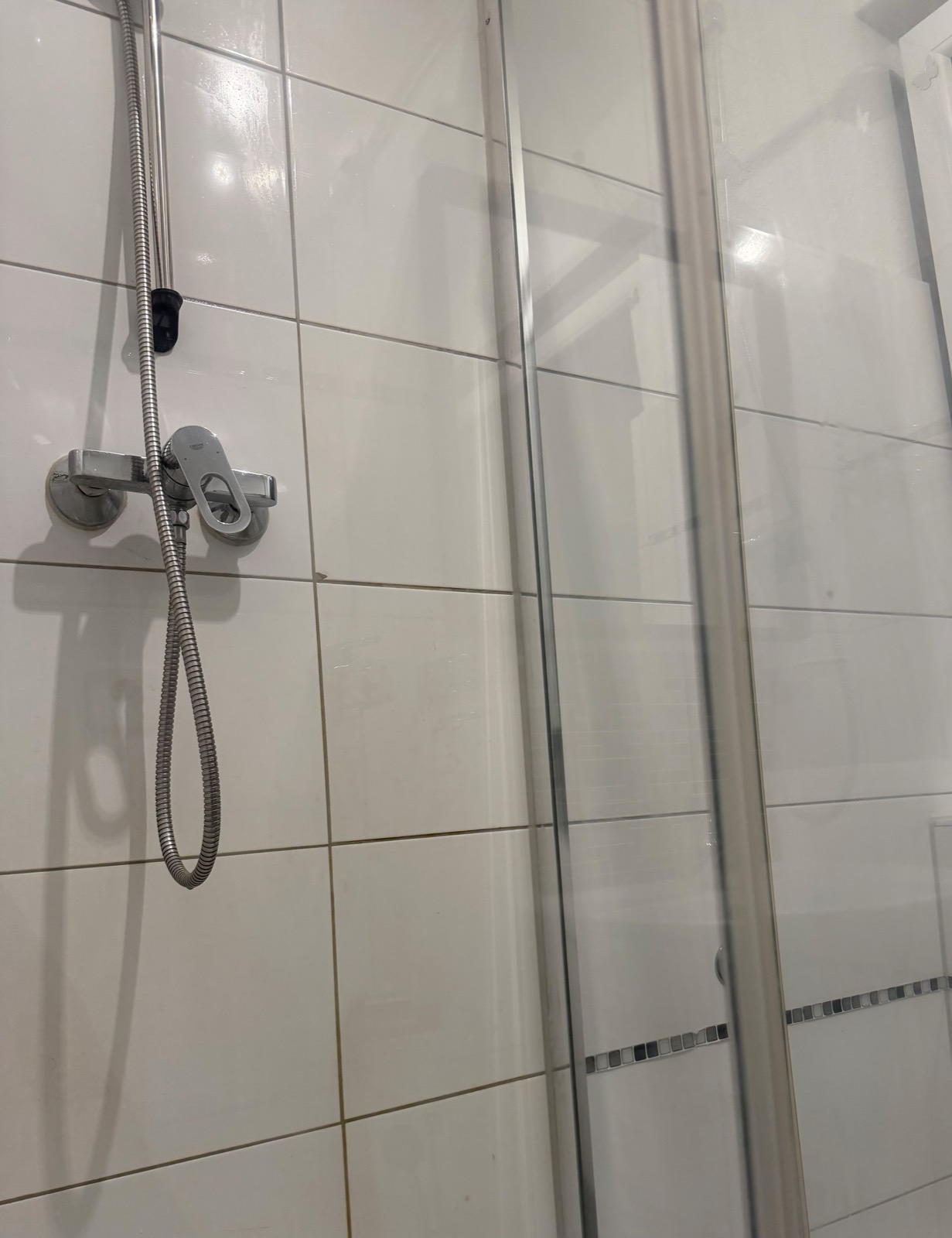 Saubere Dusche mit klarem Glas und glänzender Armatur nach der Reinigung