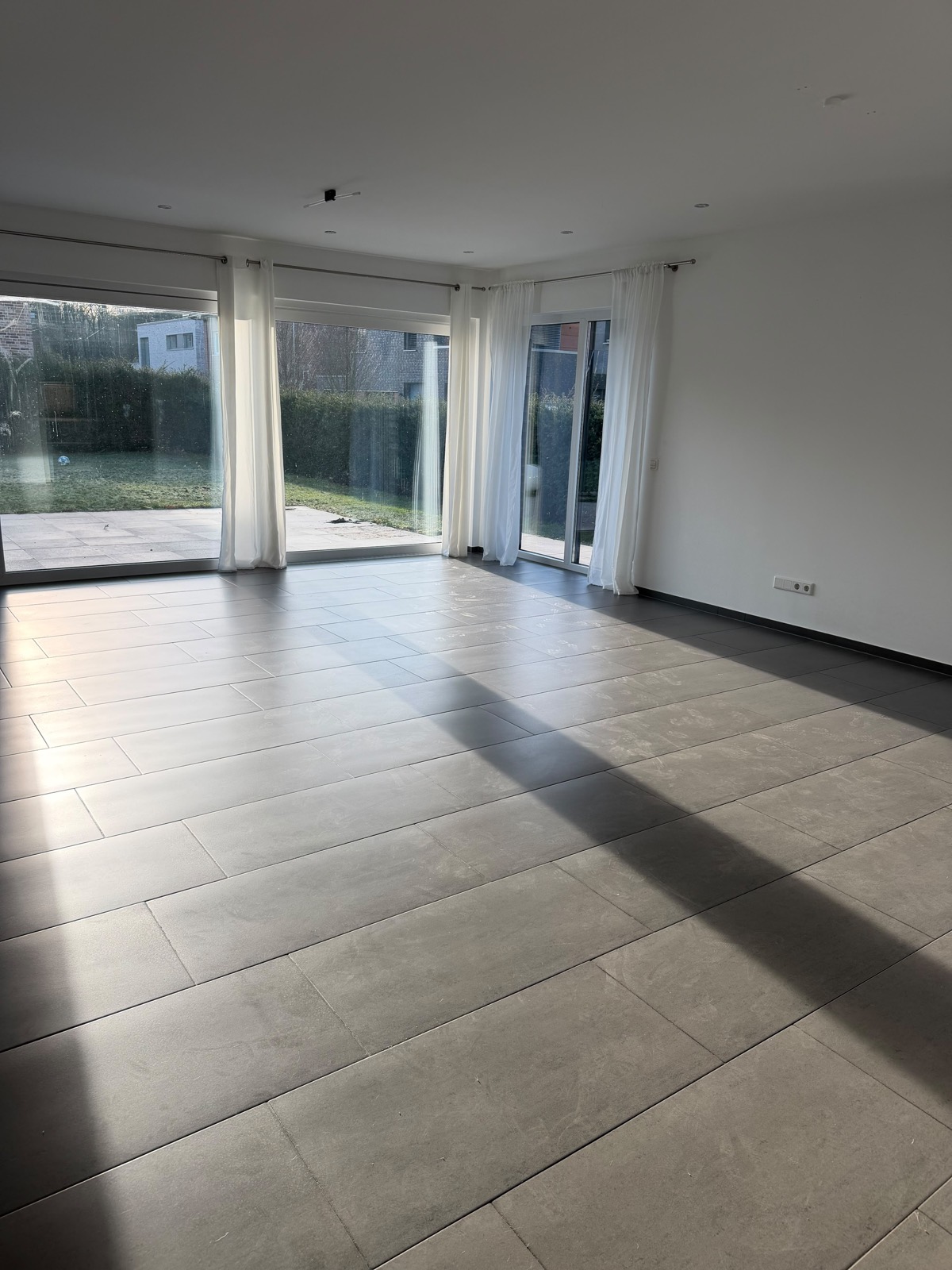 Wohnraum mit staubigem Fliesenboden vor der Grundreinigung